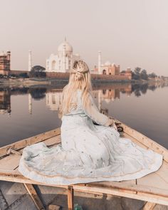 a woman sitting on top of a wooden boat