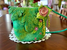 a green purse sitting on top of a wooden table