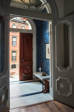 an entry way with a red door and blue walls