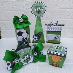 a table topped with green and white boxes filled with paper decorations next to each other