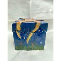 a ceramic box with an image of a woman laying on it's back in the grass