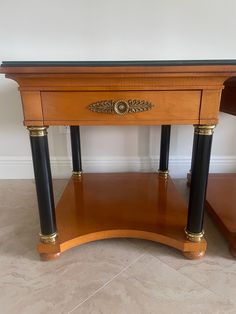 a wooden table with two black and gold legs