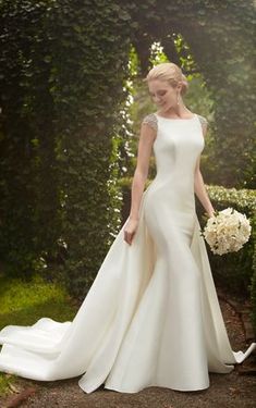 a woman in a white wedding dress standing outside