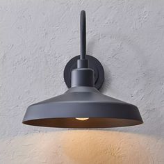 an industrial style light fixture on the wall with a dimmer and white plaster background