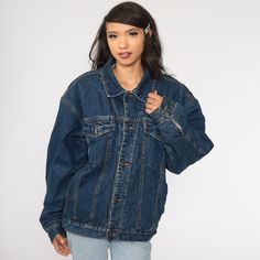 "Vintage 80s jean jacket in blue denim with a faux shearling lining. Every garment we sell is authentic vintage and one-of-a-kind! You will receive the exact item photographed. Condition: Very good vintage with light general wear. Best fits women's: Extra Large Best fits men's: large Material: denim with sherpa lining MEASUREMENTS Taken from seam to seam while the garment is lying flat. Double the armpit, waist, and hips For reference, model is 5'10\" and measures 31-23-34. Length from Top: 27\" Oversized Winter Denim Jacket, Grunge Denim Jacket For Streetwear, Winter Medium Wash Loose Fit Denim Jacket, Grunge Denim Streetwear Outerwear, Grunge Denim Outerwear For Streetwear, Retro Dark Wash Outerwear For Streetwear, Oversized 90s Denim Jacket For Streetwear, 90s Oversized Denim Jacket For Streetwear, Winter Denim Jacket For Streetwear