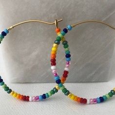 Colorful glass rainbow beads adorn a gold hoop earring. These lightweight earrings are so versatile. Cheap Rainbow Beaded Earrings For Summer, Cheap Rainbow Beaded Earrings For Party, Cheap Colorful Beads Hoop Earrings For Party, Cheap Sweet Multicolor Earrings, Cheap Trendy Earrings With Colorful Beads, Cheap Trendy Multicolor Beaded Earrings, Cheap Adjustable Earrings With Colorful Beads, Cheap Rainbow Beaded Earrings With Dangling Beads, Cheap Multicolor Earrings With Colorful Beads