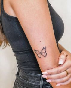 a woman with a butterfly tattoo on her arm