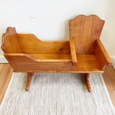 a wooden toy bench sitting on top of a white rug next to a wood floor