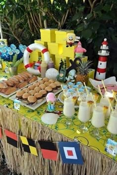 a table topped with lots of food next to a lush green forest filled with trees