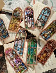 several stained glass windows sitting on top of an open book