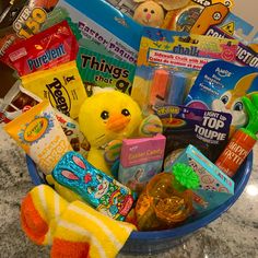 a basket filled with lots of toys on top of a marble countertop next to a stuffed animal