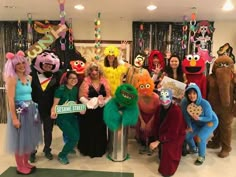 a group of people dressed up in costumes posing for a photo with sesame street characters