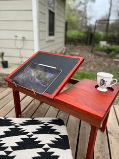 a table with a tablet on it and a coffee cup sitting on top of it