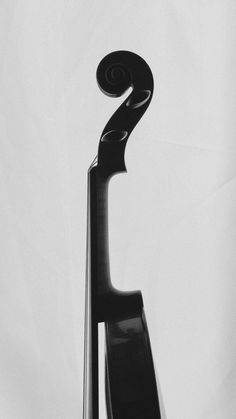 a black and white photo of a violin leaning against the back of it's stand