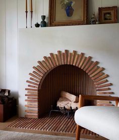 a living room with a fire place next to a chair and pictures on the wall