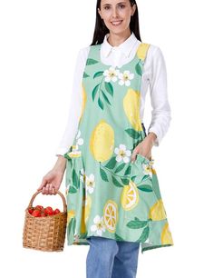 a woman in a green apron holding a basket full of lemons and cherries