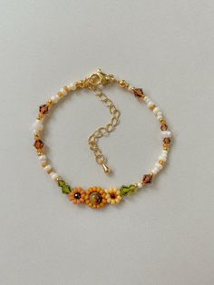 Bracelet Length: 6-8 inches  Each Bracelet has a 2 inch 14k gold filled extender This bracelet features different shades of hand woven yellow sunflowers and fall colors of cream, brown, green, and gold.  This dainty piece is made up of high quality seed beads including 24kt gold plated beads, crystals, and tigers eye. Strung on: Non-Stretchy Beading Thread Sunflower Thread Bracelet, How To Make A Sunflower Bracelet, Cheap Yellow Flower Bracelet, Fall Beads Bracelet, Beaded Sunflower Bracelet, Daisy Seed Bead Bracelet, Dainty Handmade Yellow Bracelets, Adjustable Flower Beaded Chain Jewelry, Adjustable Flower Shaped Beaded Chain Jewelry