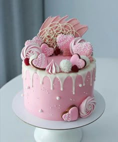 a pink cake with white icing and decorations