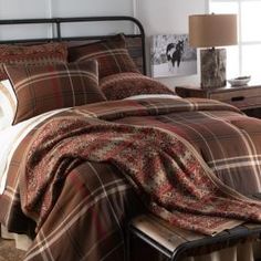 a bed with plaid comforter and pillows in a bedroom