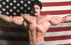 a man posing in front of an american flag