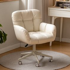 a white office chair sitting on top of a rug in front of a desk with a potted plant