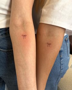 two women with matching tattoos on their arms