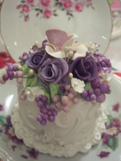 there is a white cake with purple flowers on it