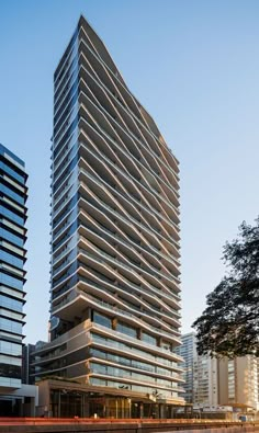 a very tall building with many windows on it's side in front of other buildings