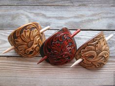 three wooden masks sitting on top of a wooden table next to each other with toothpicks sticking out of them