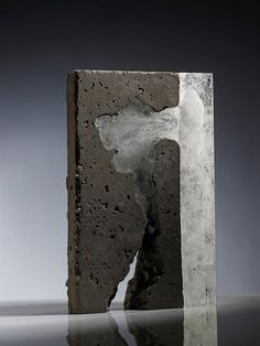 a piece of concrete that has been cut in half and is sitting on a reflective surface