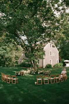 an outdoor setting with chairs and tables set up in the grass