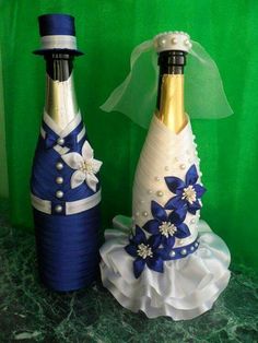 two decorated wine bottles sitting on top of a table