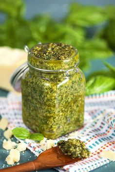 a jar filled with pesto sitting on top of a table