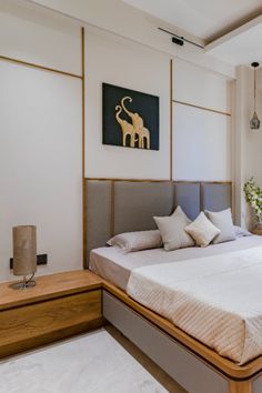 a large bed sitting in the middle of a bedroom next to a painting on the wall