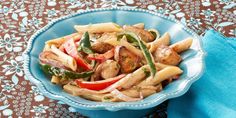 a blue bowl filled with pasta and vegetables