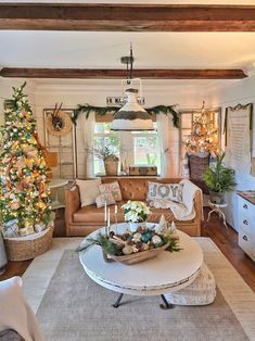 a living room filled with furniture and a christmas tree in the corner on top of a coffee table