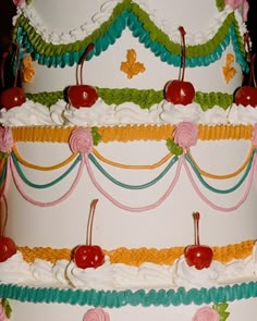 a multi layer cake with cherries and ribbons