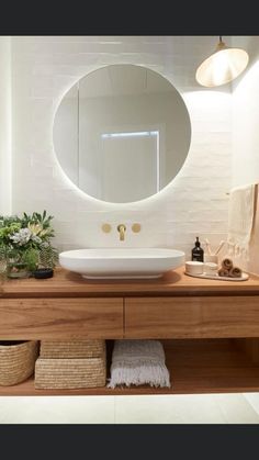 a bathroom with a round mirror above the sink