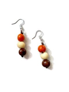 Ecuadorean Tagua Jewelry - Eco Friendly Color: Orange, Brown, Beige Item Number: TAG634 Item Weight: 1.4oz Product Length: 46 inches long About Tagua This Product is handcrafted from a palm tree nut native to the lush tropical rainforests of Ecuador. Also referred to as the Ecuadorean Ivory Palm, the Tagua tree produces several bushels of seed pods a year with up to 100 Tagua nuts per pod. These nuts are then harvested, dried, and crafted into a wide range of products from vibrant modern jewelry White Jewelry With Wooden Beads, White Jewelry With Round Wooden Beads, Beige Dangle Jewelry With Ear Wire, Beige Wooden Beads Jewelry As A Gift, Tagua Necklace, Ivory Necklace, Tagua Jewelry, Tagua Nuts, Brown And Beige