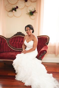 a woman in a wedding dress sitting on a couch