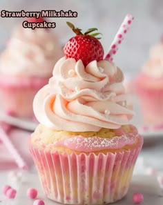 strawberry muffin cupcakes with frosting and strawberries on top, ready to be eaten