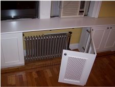 a white radiator sitting in front of a window next to a wall mounted tv