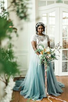 a woman standing in front of a door holding a bouquet