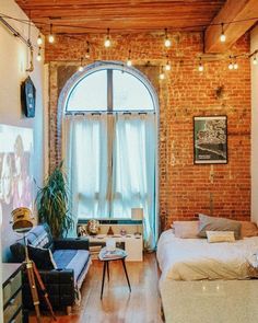 a living room filled with furniture and a brick wall