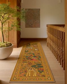 a long rug with an animal design on the floor next to a potted plant