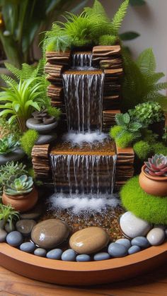 a fountain made out of books and rocks with plants in the corner around it on a wooden table