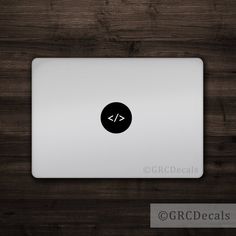 an apple macbook pro on a wooden surface with the logo for gfcdecals