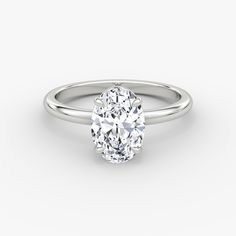 an oval cut diamond engagement ring on a white background