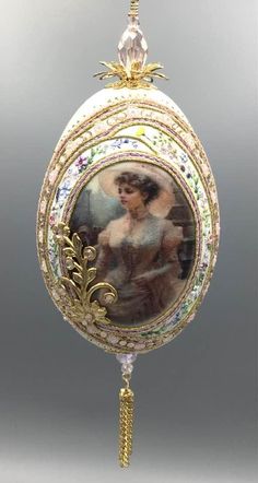 an ornate glass ornament with a painting on it's side and gold trimming