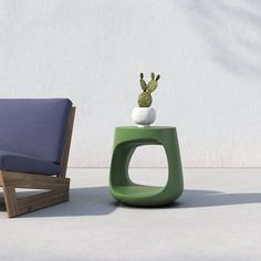 a small cactus sits on top of a table next to a modern chair and ottoman